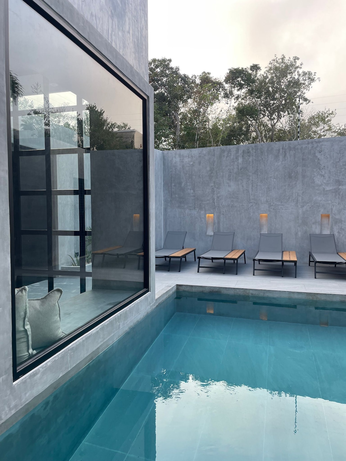 Casa Arroqueno contemporary living space featuring polished concrete finishes and jungle views