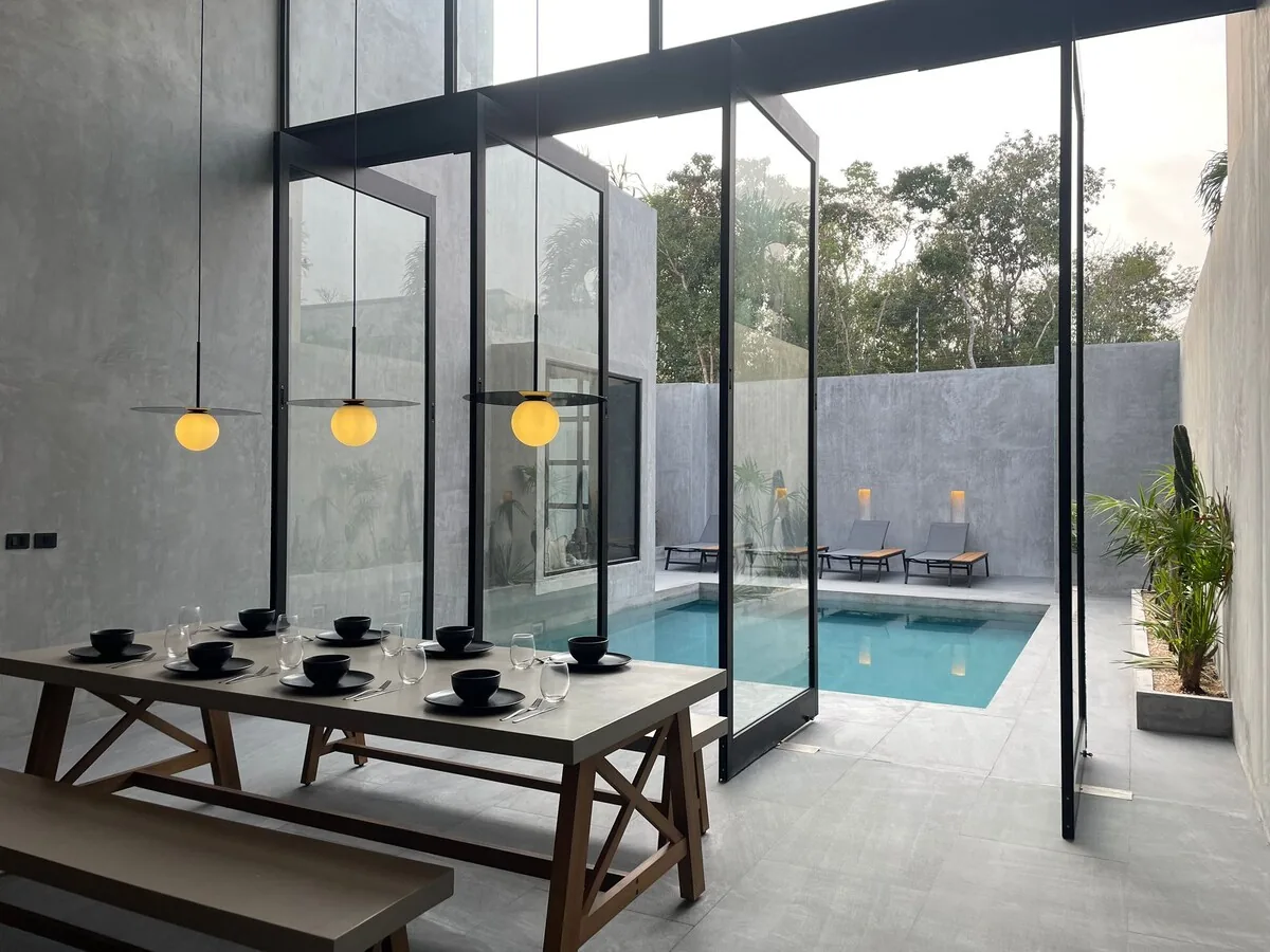 Casa Arroqueno luxury swimming pool area surrounded by lush jungle vegetation and modern architecture