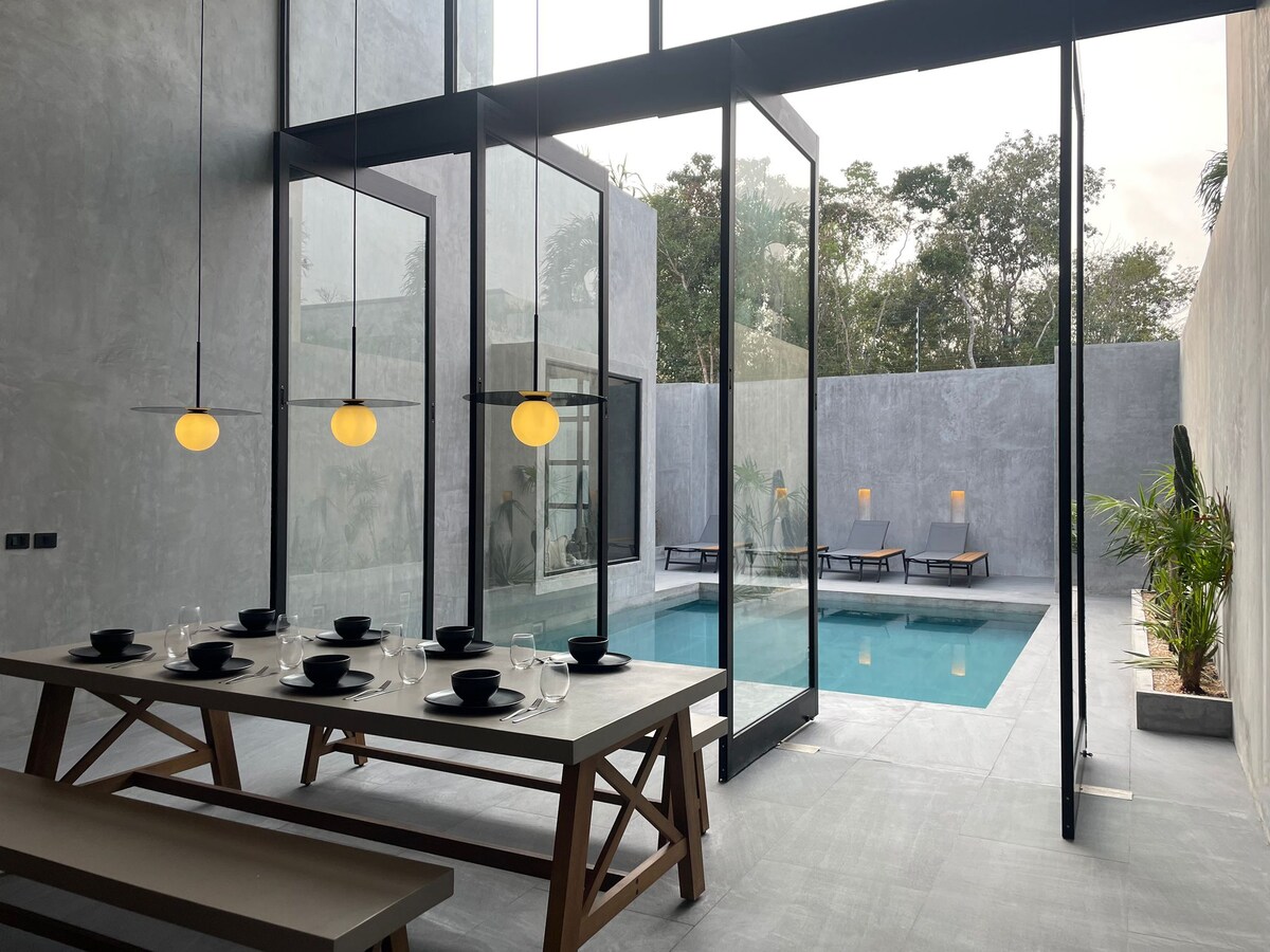 Casa Arroqueno luxury swimming pool area surrounded by lush jungle vegetation and modern architecture