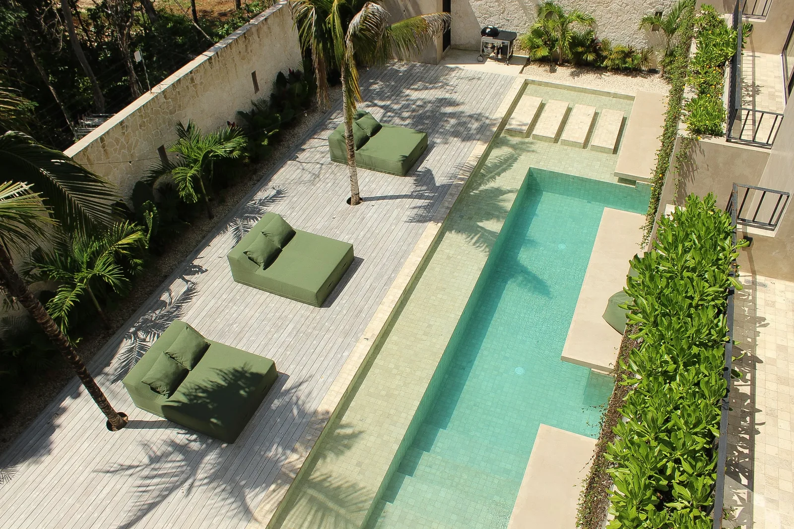 Aerial view of Casa Uulum's ground-level pool, sun deck and tropical garden
